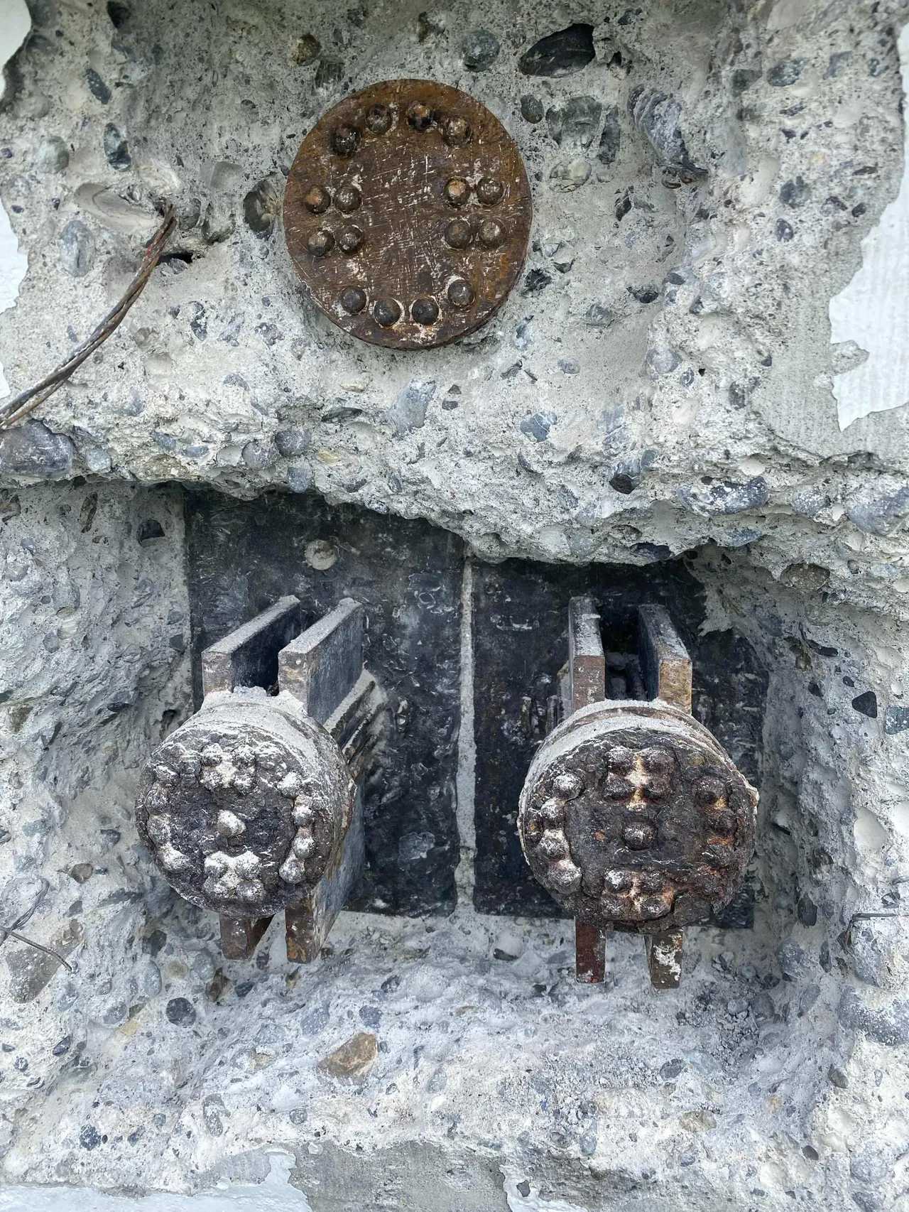 Severely corroded post-tension anchor heads and concrete cavity exposed during structural assessment and repair work.