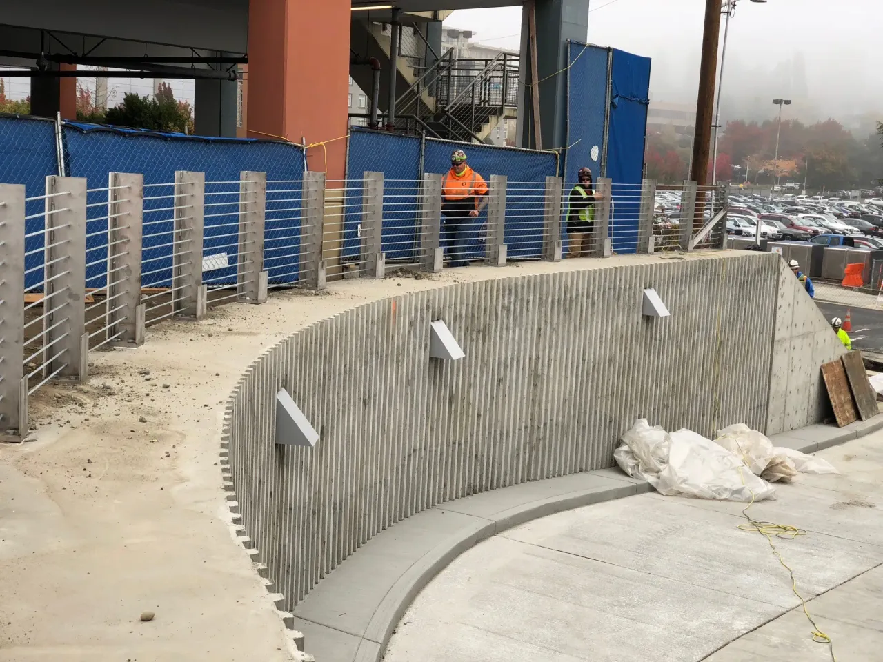 Curved concrete ramp at Northgate Station with newly installed barrier cable posts and tensioned steel cables in progress.