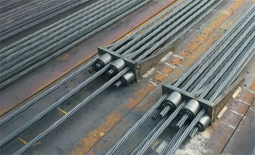 Post-tensioned tendons anchored to a steel I-beam, prepared for structural use in a Fortis Pile shoring wall system.