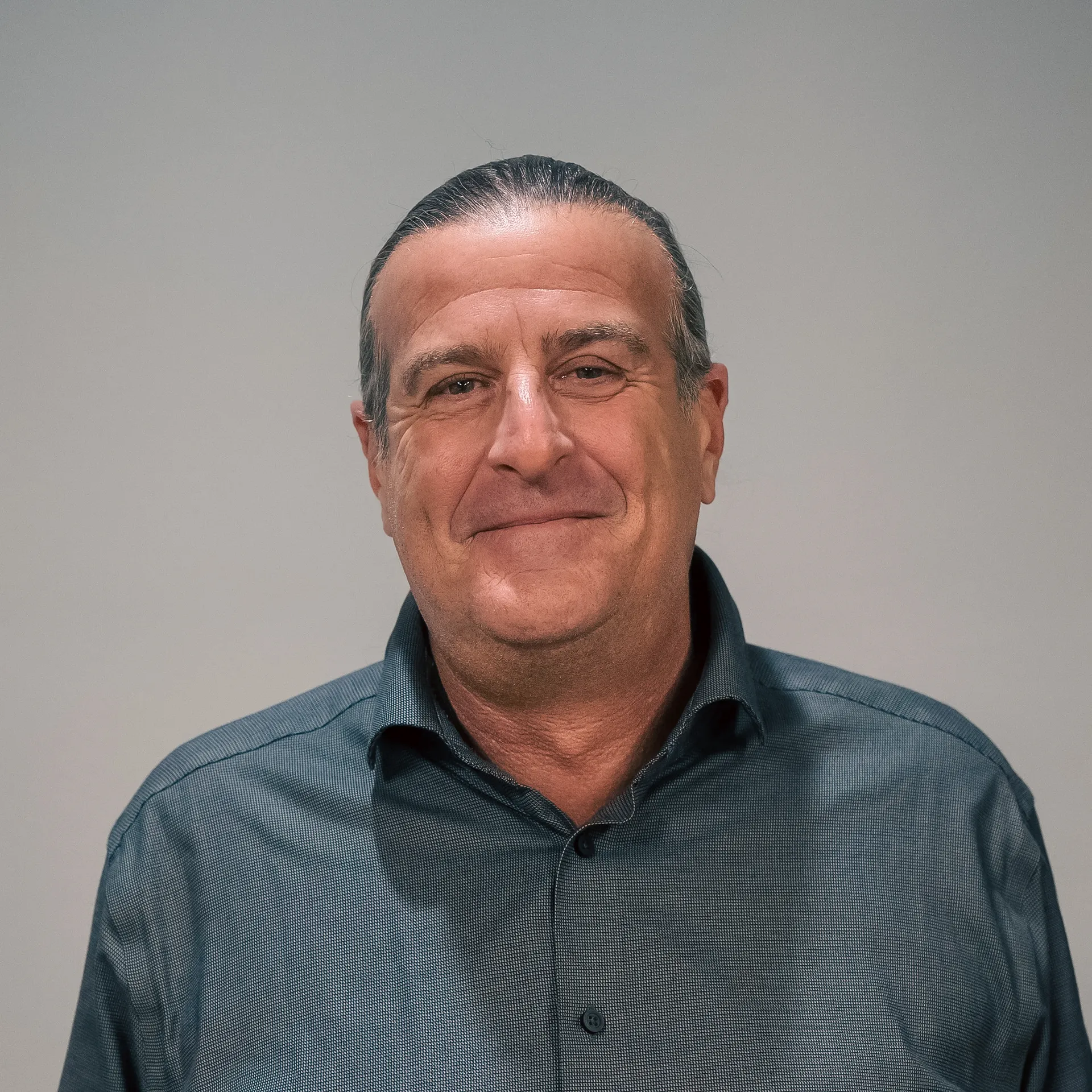 John Pagano smiling in a button-up shirt, showcasing a team member from the post-tensioning business.