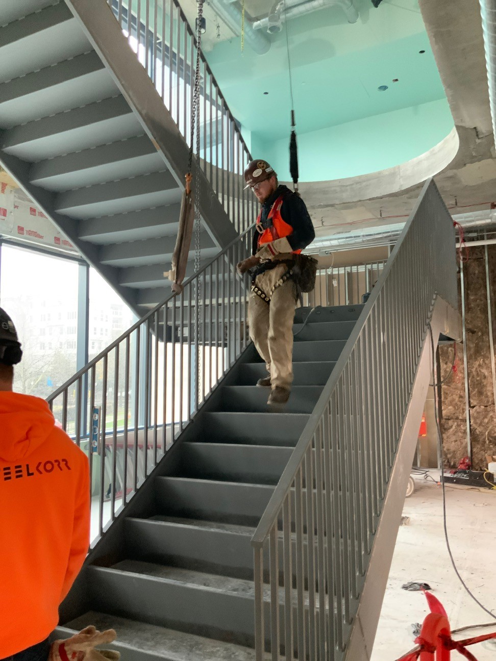 Elevator shaft retrofit tendon relocation
